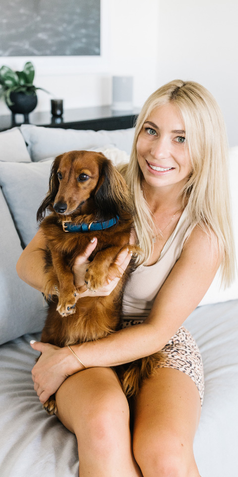blonde girl in workout clothes cuddling long haired dachshund wearing blue chasing winter collar