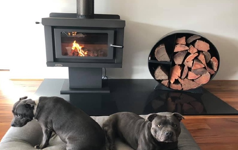 Medium sized wood heater which will heat up 220 square metres in a home setting. Two dogs in the foreground