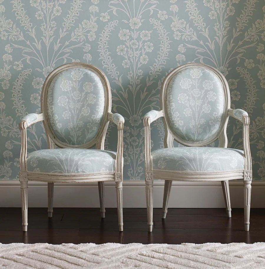 A pair of French carved and painted Louis XVI fauteuils, with oval backs, seats and armrests upholstered in Chelwood fabric, designed by Nina Campbell. With grey/white painted frames. Both chairs bears the mark of Barthelemy Denis Chardon, Paris