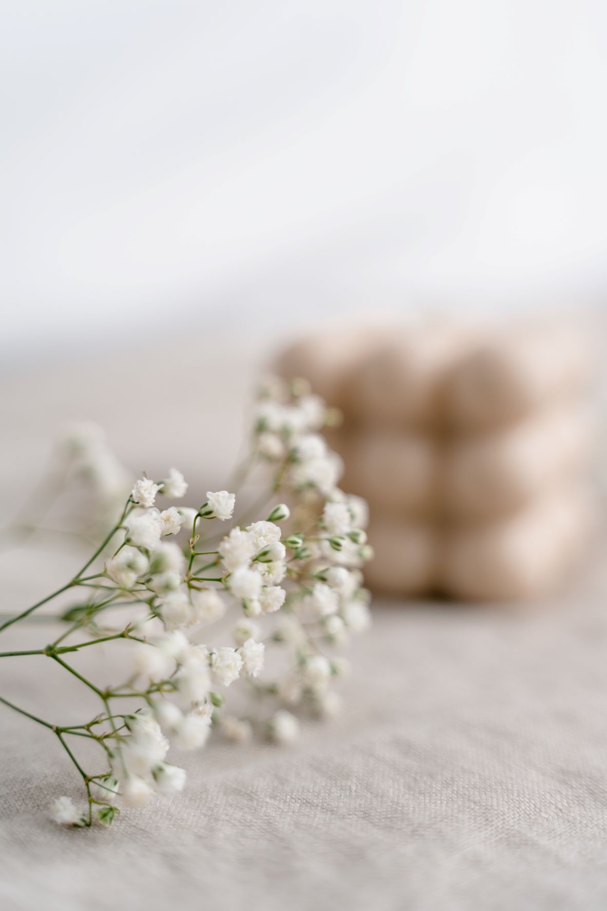 White babys breath flowers are displayed on a beige linen table cloth